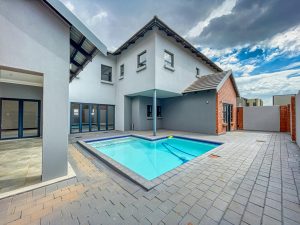 Contemporary villa exterior in Pretoria with a swimming pool and patio area.